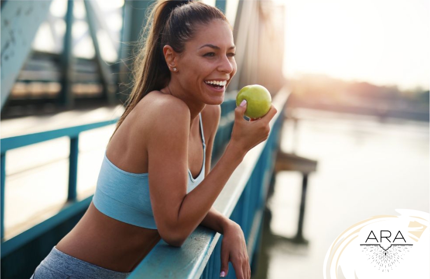 mulher comendo fruta ao ar livre, seguindo seu Lifestyle.